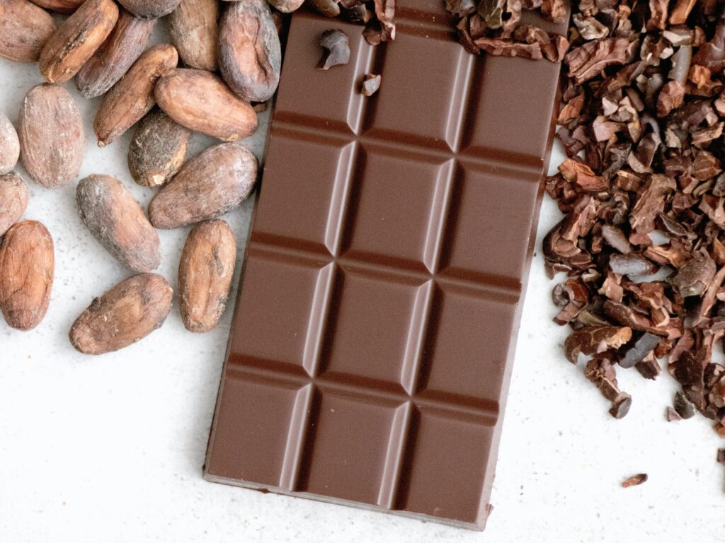 Billede af chocolade omkring af knuste kakao bønner og hele ristede kakao bønner.